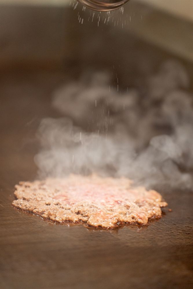 La carne recién aplastada, salada sobre la plancha
